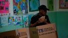 A voter holds his ballots after choosing his preferences during a general election in Panama City, Sunday, May 5, 2024. (AP Photo/Matias Delacroix)