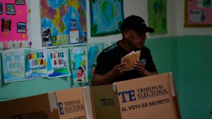A voter holds his ballots after choosing his preferences during a general election in Panama City, Sunday, May 5, 2024. (AP Photo/Matias Delacroix)