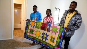 Refugees from Congo Sadock Ekyochi, from left, his wife Riziki Kashindi and her brother Kaaskile Kashindi pose for a photo inside their new apartment, Thursday, April 11, 2024, in Columbia, S.C. (AP Photo/Erik Verduzco)