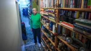 John Williams, who is losing his sight, poses for a photograph with his collection of books that he has decided to sell, in Vancouver, on Wednesday, April 24, 2024. THE CANADIAN PRESS/Darryl Dyck