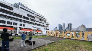 People take photos next to the Volendam cruise ship in the Port of Montreal, Saturday, May 4, 2024. The cruise ship is the first to arrive in the port this year and housed 1,500 Ukrainian refugees for several months in 2022. (Graham Hughes, The Canadian Press)