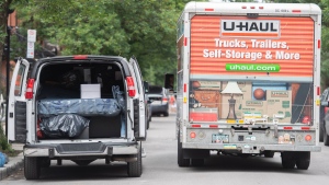 A U-Haul truck passes a van loaded with furniture on moving day in Montreal, Friday, July 1, 2022. (Graham Hughes, The Canadian Press)