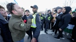 Pro-Israel protesters, left, and pro-Palestinian protesters face off as police keep the two groups separate at a demonstration in front of a synagogue in Thornhill, Ont., Thursday, March 7, 2024. THE CANADIAN PRESS/Frank Gunn