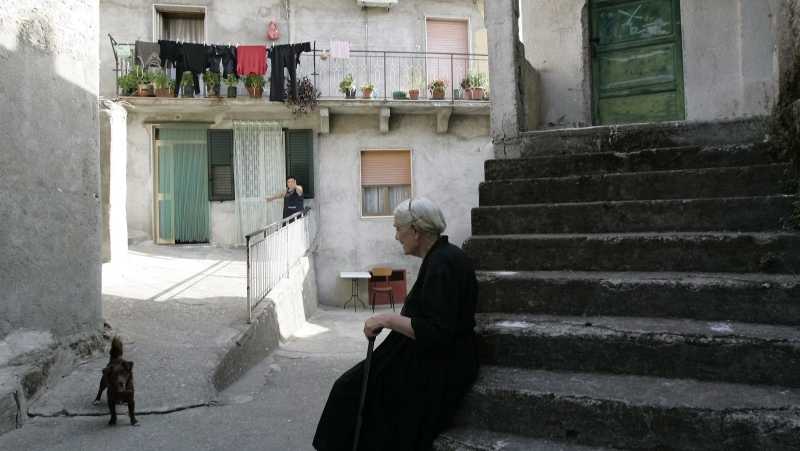 An elderly woman sits in the village of San Luca, a Calabrian town notoriously known as an organized crime stronghold, on Aug. 21, 2007. (AP Photo/Pier Paolo Cito, File)