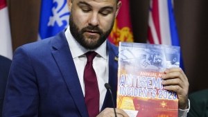 Richard Robertson holds up an Annual Audit of Antisemitic Incidents in Canada in Ottawa on Monday, May 6, 2024. (Sean Kilpatrick / The Canadian Press)