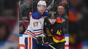 Edmonton Oilers' Connor McDavid, left, and Vancouver Canucks' Quinn Hughes watch the play during the third period of an NHL hockey game in Vancouver, on Monday, November 6, 2023. THE CANADIAN PRESS/Darryl Dyck