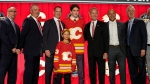Samuel Honzek poses with Calgary Flames officials after being picked by the team during the first round of the NHL hockey draft Wednesday, June 28, 2023, in Nashville, Tenn. (AP Photo/George Walker IV)