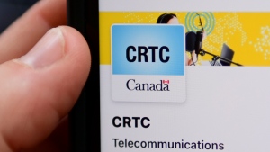 A person navigates to the online social media pages of the CRTC on a cellphone in Ottawa on Monday, May 17, 2021. THE CANADIAN PRESS/Sean Kilpatrick