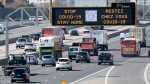 Traffic on Highway 401 in Toronto passes under a COVID-19 sign on Monday April 6, 2020. THE CANADIAN PRESS/Frank Gunn