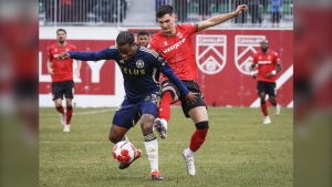 Vancouver Whitecaps defender Javain Brown controls the ball as Cavalry FC attacker Lleyton Brooks checks in Calgary on May 7, 2024. THE CANADIAN PRESS/Jeff McIntosh
