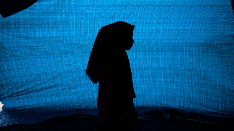 N, a 12-year-old ethnic Rohingya refugee, stands in her tent at a temporary shelter in Meulaboh, Indonesia, on Thursday, April 4, 2024. (AP Photo/Reza Saifullah)