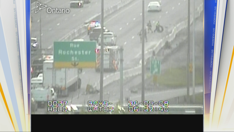 Ottawa firefighters help cleanup debris after a transport truck struck a guardrail on Hwy. 417 at Bronson Avenue Wednesday morning. (Ministry of Transportation cameras/CTV Morning Live)