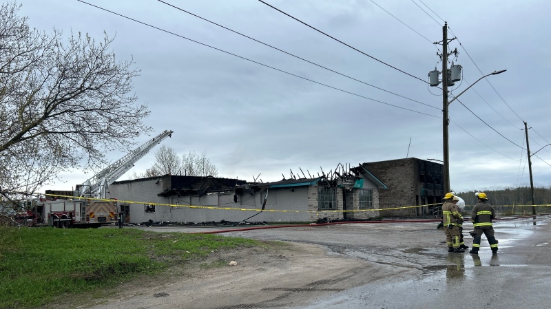 North Bay firefighters stand infront of burned out Stradwicks flooring store. May 8, 2024 (Eric Taschner/CTV Northern Ontario)