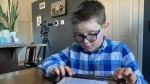 Isaiah Gauthier, 10, uses his braille machine to search on the internet. (CTV News)