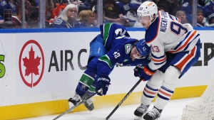 Vancouver Canucks' Quinn Hughes is tripped up by Edmonton Oilers' Ryan Nugent-Hopkins during the second period in Game 1 of an NHL hockey Stanley Cup second-round playoff series, in Vancouver, on Wednesday, May 8, 2024. THE CANADIAN PRESS/Darryl Dyck