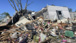 A storm-damaged mobile home is surrounded by debris at Pavilion Estates mobile home park just east of Kalamazoo, Mich. Wednesday, May 8, 2024. (AP Photo/Joey Cappelletti)