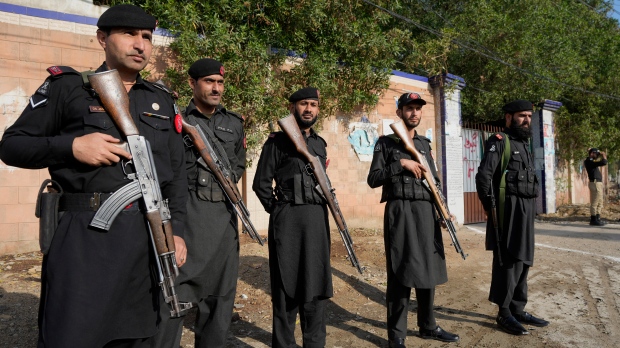 Police officers stand guard outside a polling station for security during the country's parliamentary elections, in Karachi, Pakistan, Thursday, Feb. 8, 2024. (AP Photo/Fareed Khan) 