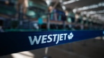A WestJet logo is seen in the domestic check-in area at Vancouver International Airport, in Richmond, B.C. (Darryl Dyck/The Canadian Press)