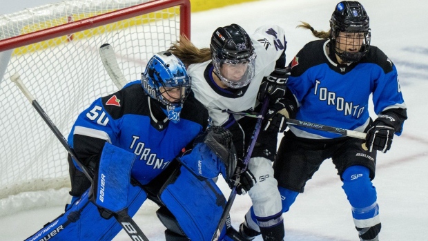 Toronto goaltender Kristen Campbell (50) battles for position with Minnesota's Abby Boreen (24) as Toronto Kali Flanagan (6) jumps in during second period PWHL playoff hockey action in Toronto on Friday, May 10, 2024.THE CANADIAN PRESS/Frank Gunn