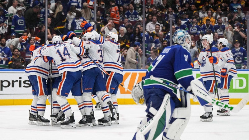 Edmonton Oilers players celebrate Evan Bouchard's winning goal as Vancouver Canucks goalie Arturs Silovs, front right, skates off the ice during on Friday, May 10, 2024. (THE CANADIAN PRESS/Darryl Dyck)