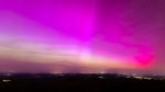Northern lights appear in the night sky over the Pferdskopf near Treisberg in the Hochtaunus district of Hesse, Germany, early Saturday, May 11, 2024. (Lando Hass/dpa via AP)