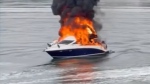 Thick black smoke is seen billowing from a boat engulfed in flames in the Sydney Harbour.