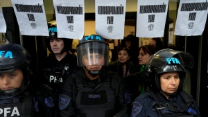 Police stand guard outside the National Institute against Discrimination, Xenophobia, and Racism, to prevent workers from entering after they were laid off in Buenos Aires, Argentina, Wednesday, April 3, 2024. (AP Photo/Natacha Pisarenko)