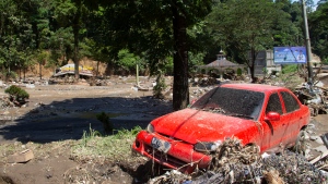 The wreckage of a car lies in a village affected by a flash flood in Tanah Datar, West Sumatra, Indonesia, Sunday, May 12, 2024. (AP Photo/Fachri Hamzah)