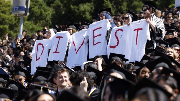 Pro-Palestinian students hold white t-shirts stating the message, "DIVEST," as they protest during the UC Berkeley graduation at California Memorial Stadium in Berkeley, Calif., on Saturday, May 11, 2024. (Yalonda M. James/San Francisco Chronicle via AP)