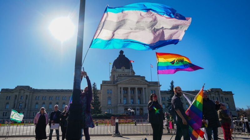 People hold pride flags while attending rally against the Saskatchewan government's proposed legislation on pronoun policy in front of Saskatchewan legislature in Regina, on Tuesday, October 10, 2023. THE CANADIAN PRESS/Heywood Yu