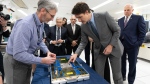 Prime Minister Justin Trudeau looks at a module test board during a tour of IBM in Bromont, Que., Friday, April 26, 2024. THE CANADIAN PRESS/Christinne Muschi