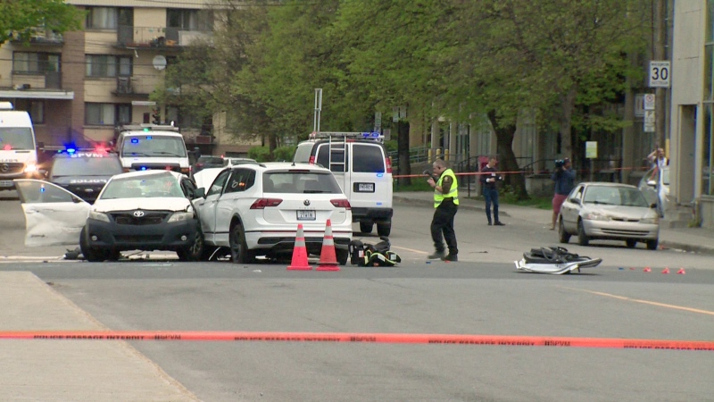 A police officer takes photographs at the scene of a collision near the intersection of Ferrier Street and Decarie Boulevard in Montreal on Monday, May 13, 2024. (Cosmo Santamaria/CTV News)