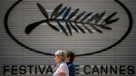 Two people walk past the Cannes film festival logo during preparations for the 77th international film festival, Cannes, southern France, Monday, May 13, 2024. The Cannes film festival runs from May 14 until May 25, 2024. (AP Photo/Andreea Alexandru)