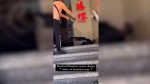 Screenshot of a video posted on Instagram in which a man is seen throwing water on a homeless person sleeping outside of a business to wake him up and make him leave. (Source: @kekecalixte/Instagram)