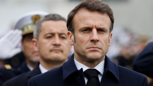 French Interior Minister Gerald Darmanin, centre, and French President Emmanuel Macron, right, attend a ceremony in Versailles, west of Paris, Friday March 31, 2023.(Ludovic Marin, Pool via AP) 
