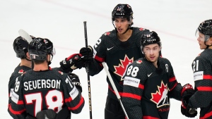 Dylan Cozens, center, celebrates with teammates after scoring his sides first goal during the preliminary round match between Austria and Canada. (Petr David Josek/AP Photo)