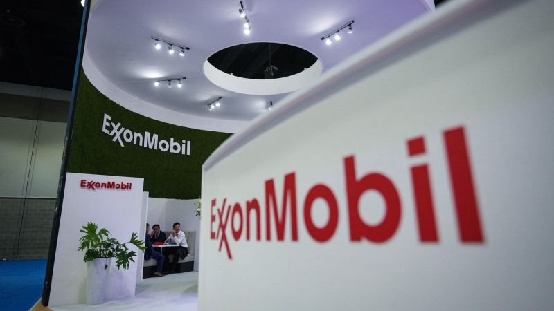 Delegates meet at the Exxon Mobil booth during the LNG2023 conference, in Vancouver on July 11, 2023. (Darryl Dyck/The Canadian Press)
