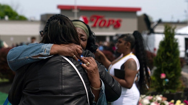FILE - Kaye Chapman-Johnson, sister of shooting victim Geraldine Talley, hugs high-school friend Sylvia McNeil outside the Tops Friendly Market during a remembrance event in honour of the victims of last year's racist attack at the supermarket, on Sunday, May 14, 2023, in Buffalo, N.Y. (Joshua Bessex/The Buffalo News via AP)