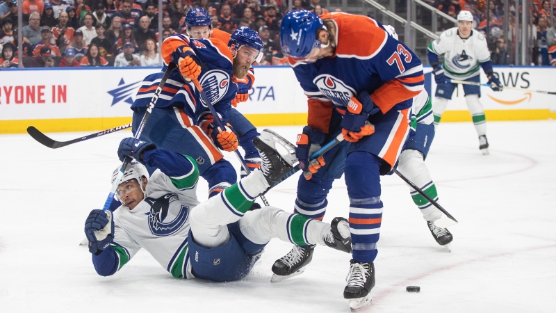 Edmonton Oilers defenceman Vincent Desharnais checks Vancouver Canucks forward Dakota Joshua during NHL playoff action on May 14, 2024, in Edmonton.