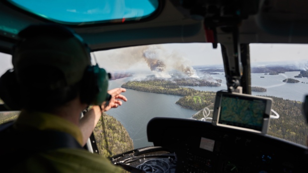 Manitoba Wildfire Service Area Fire Manager Sam Done surveys wildfires burning in northern Manitoba from a helicopter on Tuesday, May 14, 2024. THE CANADIAN PRESS/David Lipnowski