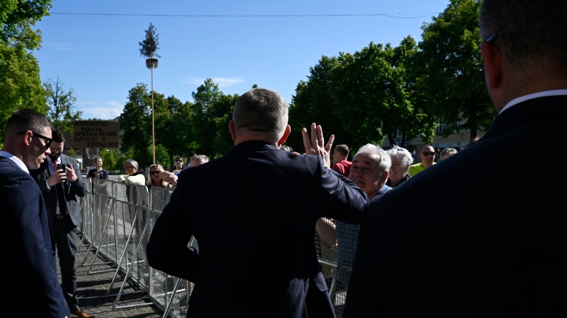 Slovakia's Prime Minister Robert Fico, centre, back to the camera, waves people before the cabinet's away-from-home session in the town of Handlova, Slovakia, Wednesday, May, 15, 2024. (Radovan Stoklasa/TASR via AP)