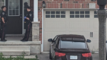 Two Waterloo Regional Police Service officers stand outside a home in the Doon South area on May 14, 2024. (Viewer submitted)