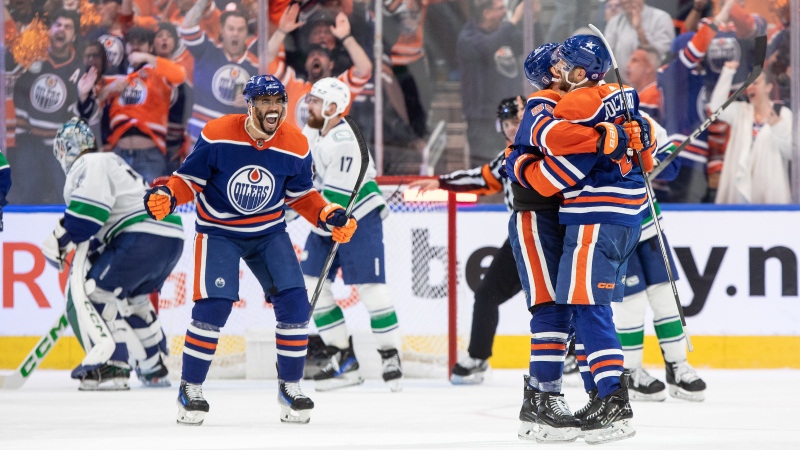 From left, Edmonton Oilers players Evander Kane, Dylan Holloway and Evan Bouchard celebrate Bouchard's goal on May 14, 2024, against the Vancouver Canucks. The goal won the game for the Oilers, tying the second-round NHL playoff series at two games each. (Jason Franson/The Canadian Press)
