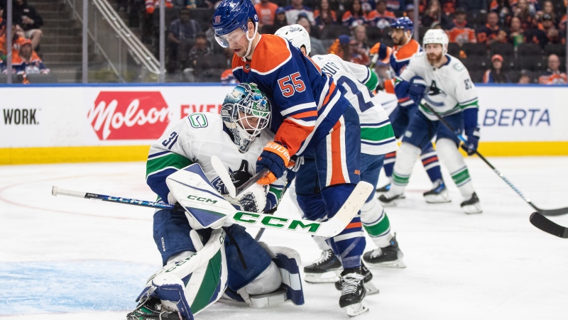 Vancouver Canucks goalie Arturs Silovs makes a save as Edmonton Oilers forward Dylan Holloway looks for a rebound on May 14, 2024, second-round NHL playoff action in Edmonton. (Jason Franson/The Canadian Press)