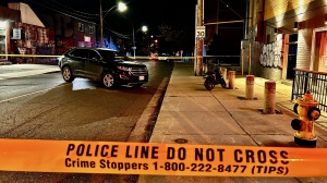 Police tape cordons off the scene where an unmarked police vehicle collided with a motorized scooter on Niagara Street Thursday May 16, 2024. (Mike Nguyen /CP24)