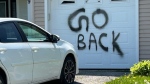 Graffiti with the message 'Go Back' is spray-painted on the garage door of a home on D'Ambrosio Drive in Barrie, Ont., on Thurs., May 16, 2024. (CTV News/Mike Lang)