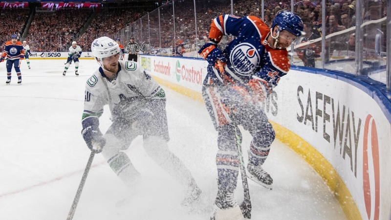 Vancouver Canucks' Elias Pettersson (40) checks Edmonton Oilers' Brett Kulak (27) during first period second-round NHL playoff action in Edmonton on Tuesday May 14, 2024. (THE CANADIAN PRESS/Jason Franson)