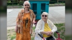 Gisela Filion, right, poses with her friend and neighbour Carol Burman in front of the little free library Filion paid to have set up outside The Federal Store in Mount Pleasant. (Carol Burman)