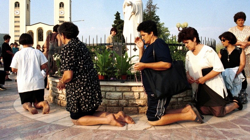 Bosnian Roman Catholic women pray on the occasion of the feast of the Assumption in Medjugorje, some 120 kilometers (75 miles) south of the Bosnian capital Sarajevo on Tuesday, August 15, 2000. (AP Photo/Hidajet Delic, File)