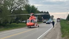 An Ornge helicopter sits on a road in Wellington County after a farm tractor rollover on May 17, 2024. (Courtesy: OPP)
